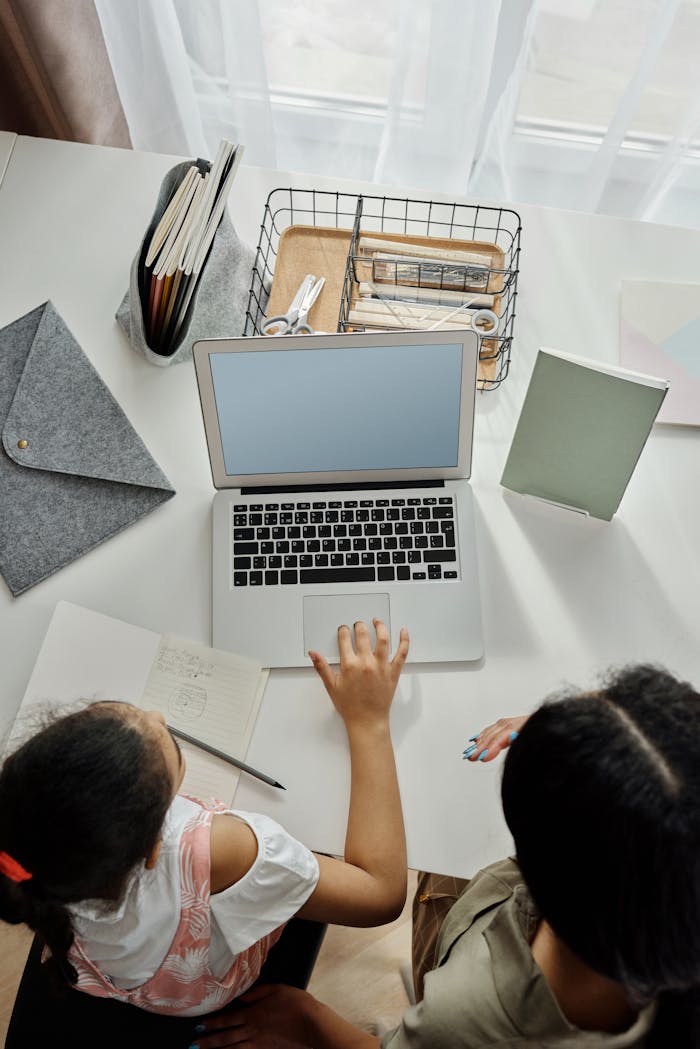 Crafting Captivating Headlines: Your awesome post title goes here Overhead view of a mother helping her daughter with online learning at home.